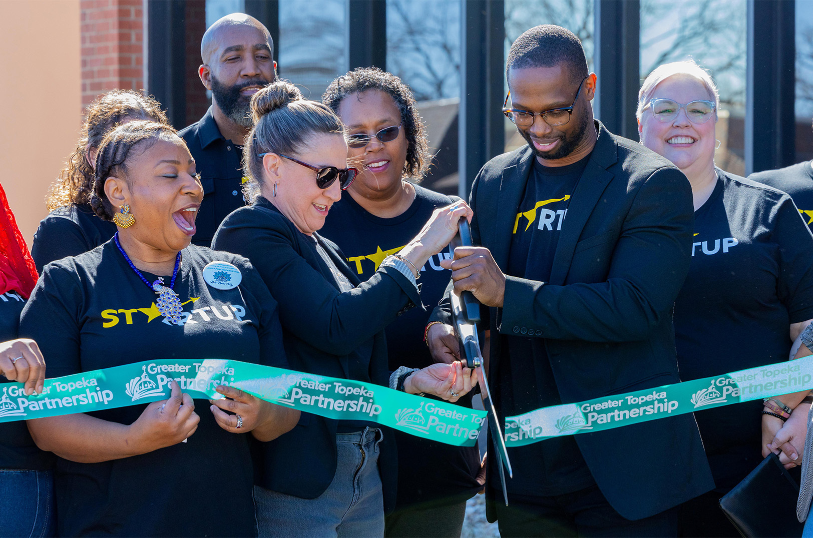 Stephanie Moran, Go Topeka, and Michael Odupitan, Omni Circle, cut the ceremonial ribbon on the Topeka Startup Community program during a launch event at Omni Circle in Topeka; photo courtesy of Omni Circle