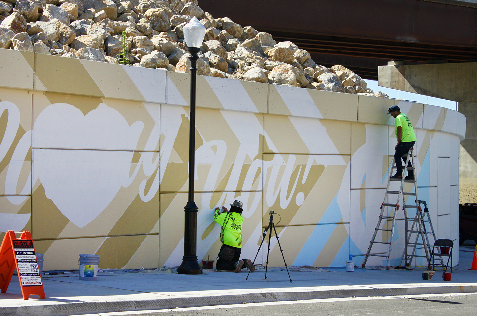 Phil “Sike Style” Shafer, center, works on a mural along the south end of the Buck O'Neil Bridge; photo by Nikki Overfelt Chifalu, Startland News
