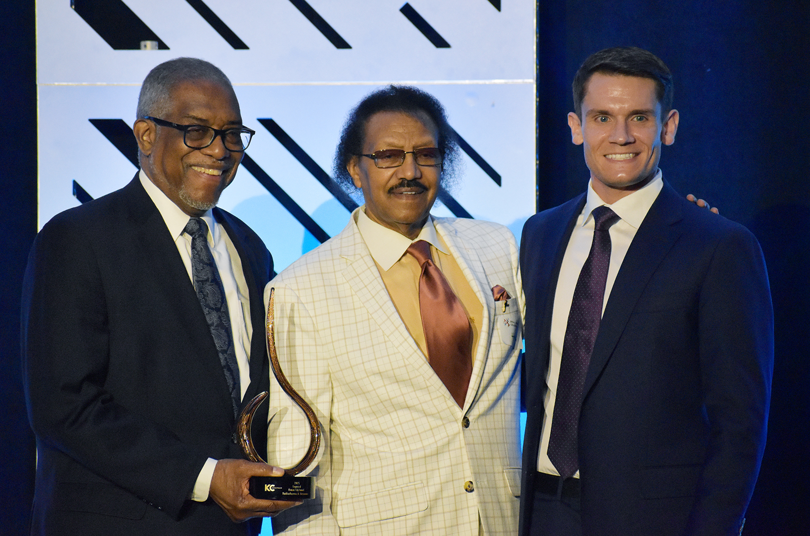 Leonard Graham and Hagos Andebrhan, T&B, Taliaferro & Browne, accept the Legacy of Kansas City Award from Peter Flynn, director of investor relations for Evergy, during the KC Chamber's Small Business Celebration; photo by Nikki Overfelt Chifalu, Startland News