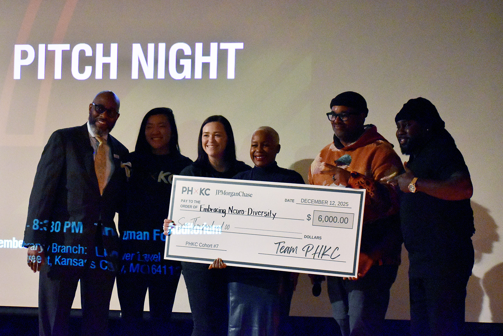 Ivory Duncan, center, founder of Embracing Neuro-Diversity, accepts the first-place prize in The Porter House KC's pitch competition between Cohort 7 members; photo by Nikki Overfelt Chifalu, Startland News