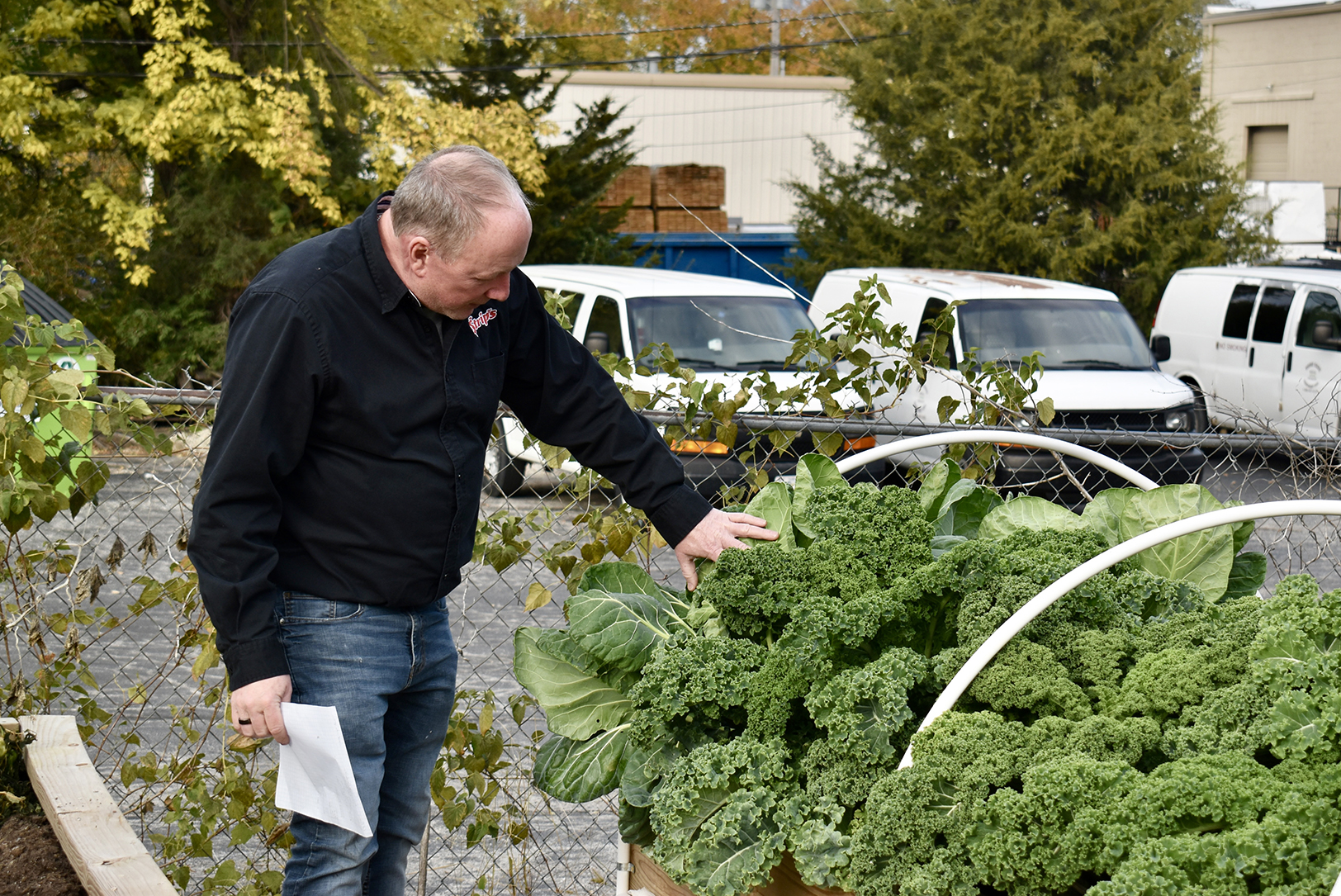 Todd Johnson, founder of Strips Chicken and Brewing, showcases the produce grown outside his Lenexa restaurant location; photo by Nikki Overfelt Chifalu, Startland News