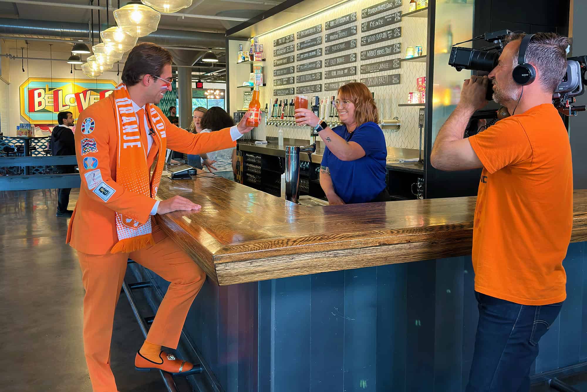 Daniel Oordt, The Oranje Suit Man, shares a cheers with members of the Boulevard team during filming at the Boulevard Tours & Rec Center in Kansas City; photo by Joyce Smith