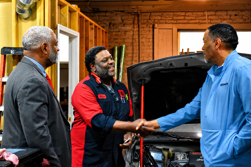 Maceo Davis, owner of Davis Auto Repair & Tow, shakes hands with visitors during the Connections Express bus tour; photo by Taylor Wilmore, Startland News