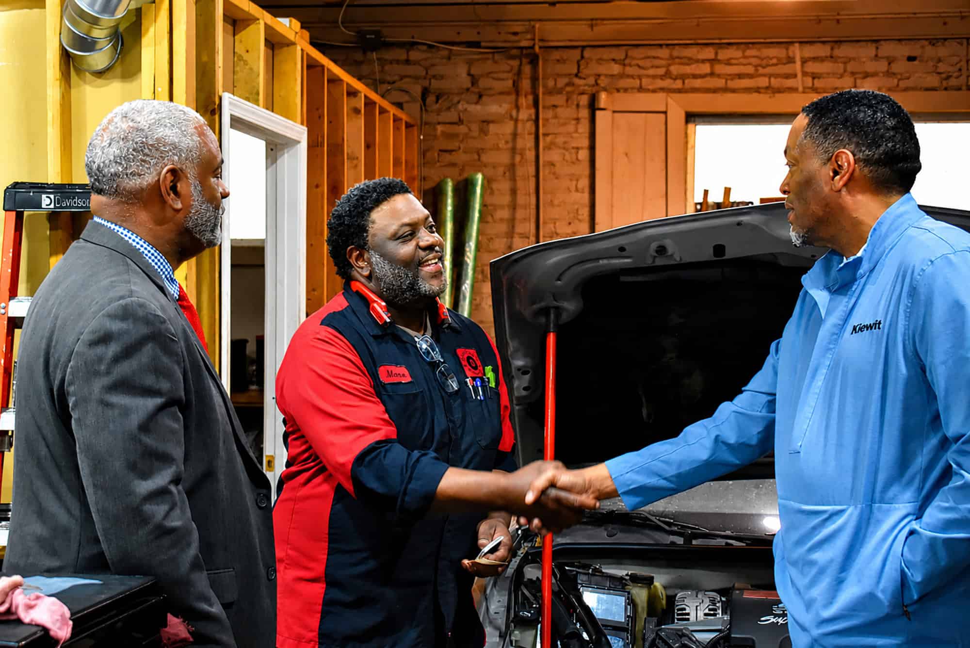 Maceo Davis, owner of Davis Auto Repair & Tow, shakes hands with visitors during the Connections Express bus tour; photo by Taylor Wilmore, Startland News