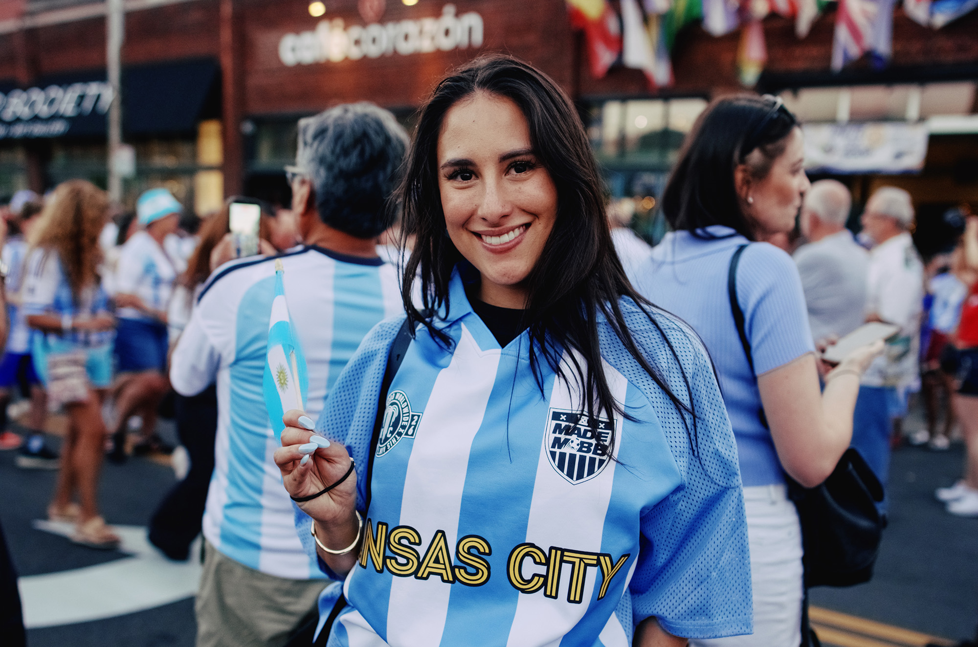 Dulcinea Herrera, owner of Café Corazón, sports MADE MOBB's new Team KC Argentina Jersey during a fan gathering that spilled from her coffee shop into Southwest Boulevard the night before Argentina's match against Algeria; photo by Frank Pham