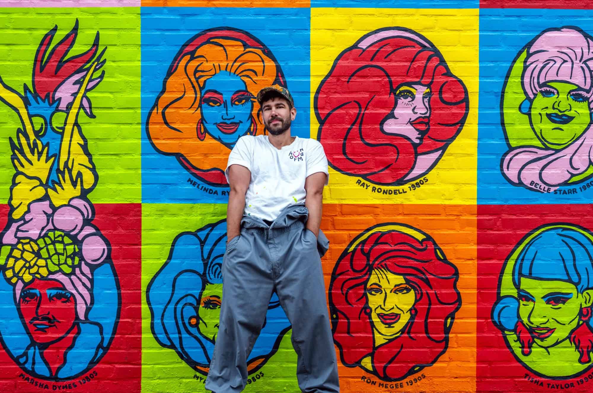 Jared Horman smiles between portraits of Melinda Ryder and Ray Rondell; photo by John Brant