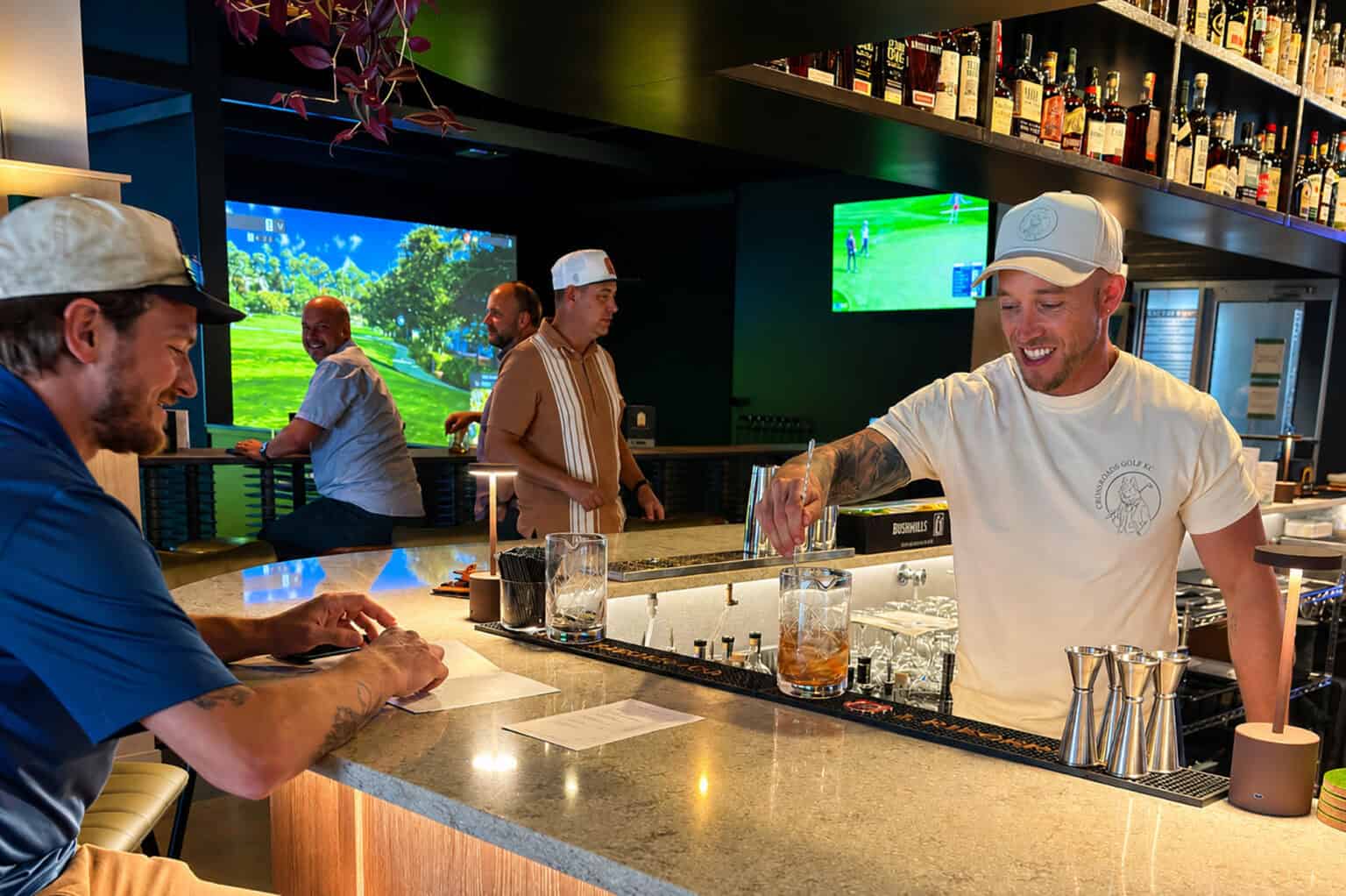 Bartender Kevin Kraft serves a cocktail during a soft opening for Crossroads Golf at 1656 Washington St., Suite 100; photo by Joyce Smith