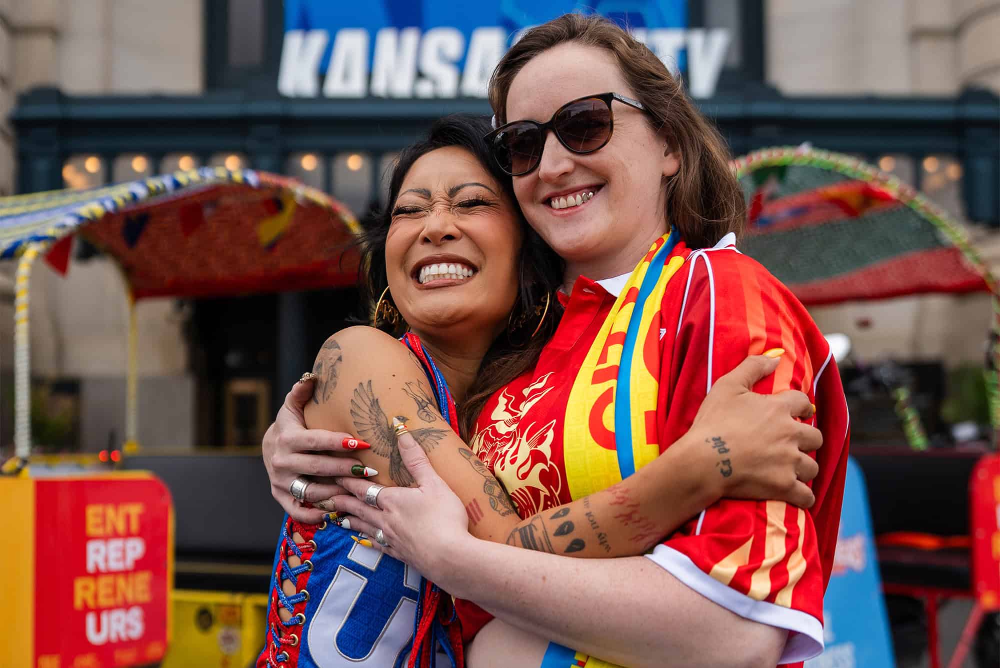 Jackie Nguyen, Cafe Cà Phê, and Paige Beltowski, Cut & Sew Production KC, embrace outside Union Station; photo by Phon Wills