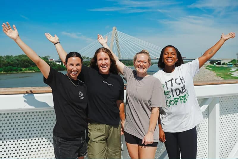 A promotional image featuring the co-founders of Pitchside Coffee at the riverfront near CPKC Stadium; photo courtesy of the Kansas City Current